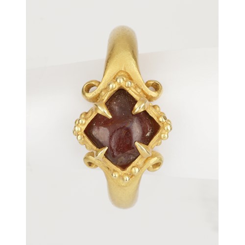 A Fine Temple Ring Set with a Rough Garnet and Raised, Lobed Bezel